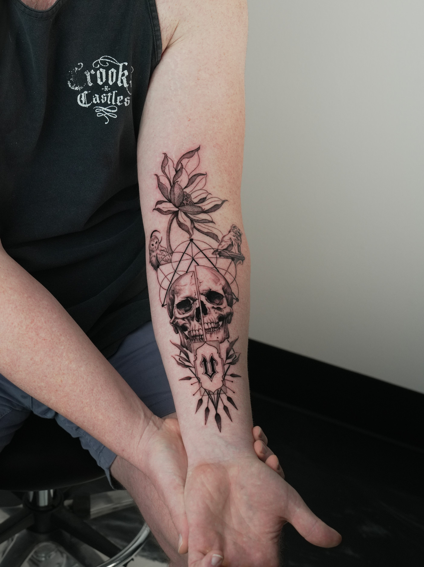 Skull, lotus and sacred geometry forearm tattoo